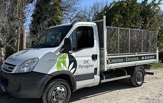 Camion TPC Paysagiste rempli de branches d'arbres coupées durant une intervention chez un client